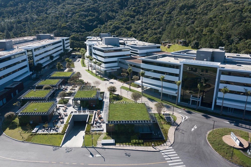 Vista aérea do Square SC, o parque empresarial na Rodovia José Carlos Daux onde fica o escritório da Wisen, em Florianópolis, com o morro da Mata Atlântica ao fundo.